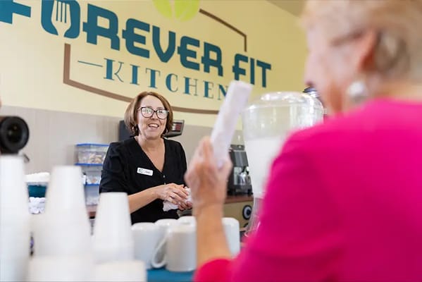 Staff serving residents in a kitchen setting
