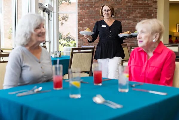 Staff serving meals to residents in the dining area