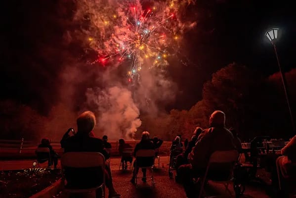Residents watching a fireworks display outdoors
