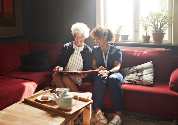 A caregiver and resident sharing a moment in a cozy common area