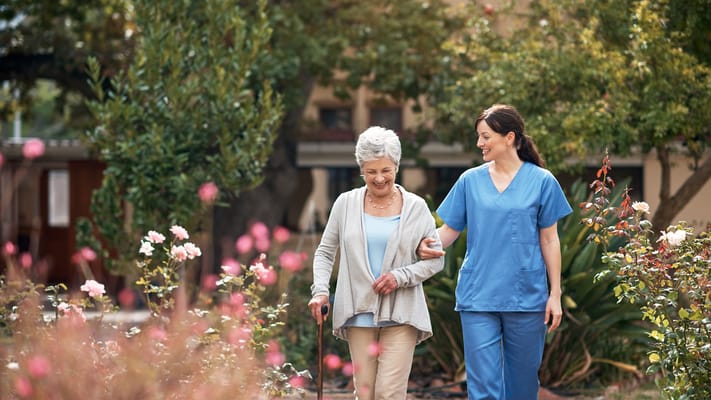 Staff member assisting a resident in a garden