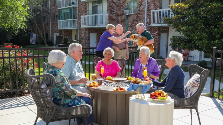 Residents enjoying outdoor activities with food and a dog
