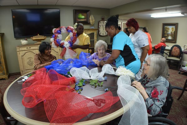 Residents and staff creating decorations in a common area