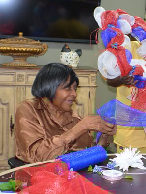 A resident crafting a wreath in a common area