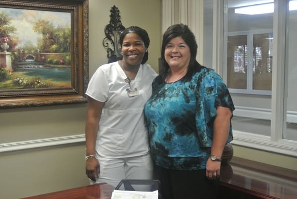 Staff member and guest posing in an office area