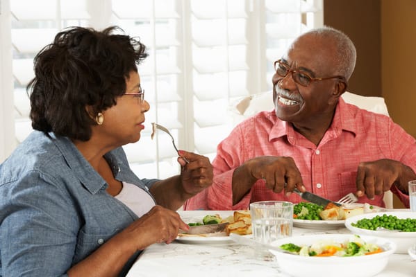 Two residents enjoying a meal together in a dining room