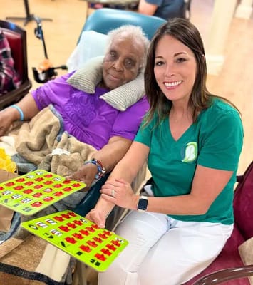Resident and staff playing bingo in an activity room