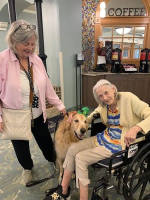 Residents and staff interacting with a therapy dog