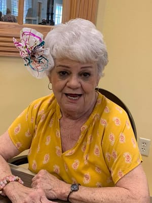 Resident smiling with a flower accessory in her hair