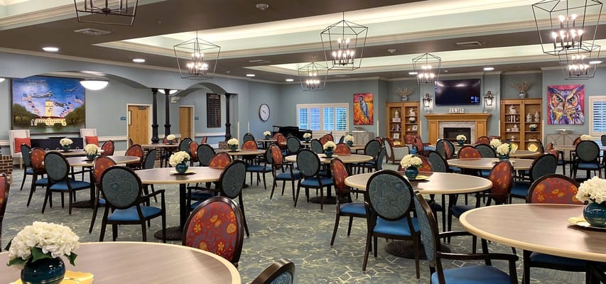 Bright dining room with round tables and flower centerpieces