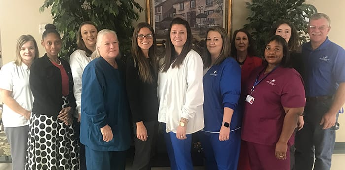 Staff members posing together in a common area