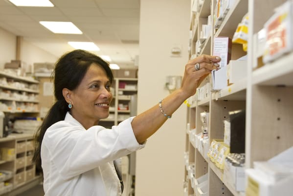 Staff member organizing medication on shelves
