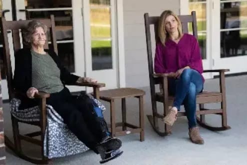 Residents enjoying their time on the porch in rocking chairs