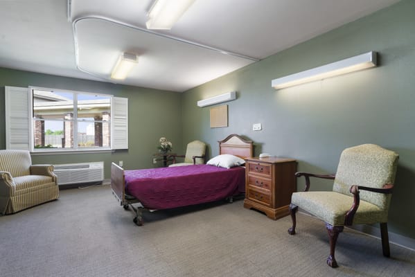 A private resident room with a bed and seating