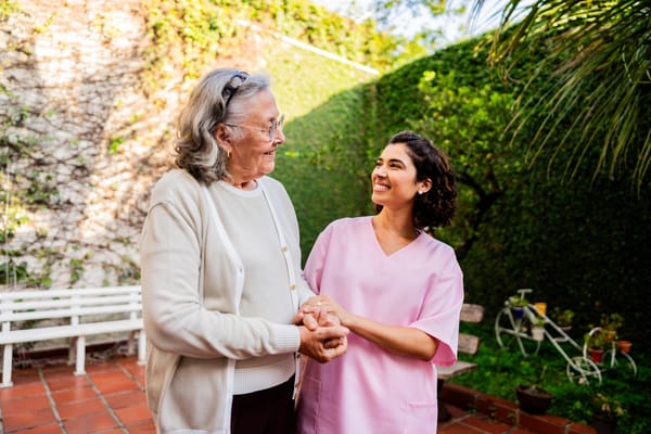 A caregiver and resident sharing a joyful moment outdoors