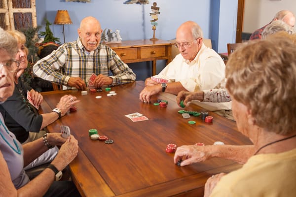 Residents engaged in a card game around a table