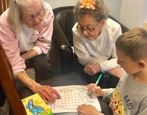 Residents and a child engaged in a puzzle activity