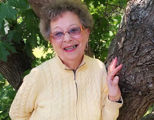 Smiling resident enjoying outdoors near a tree