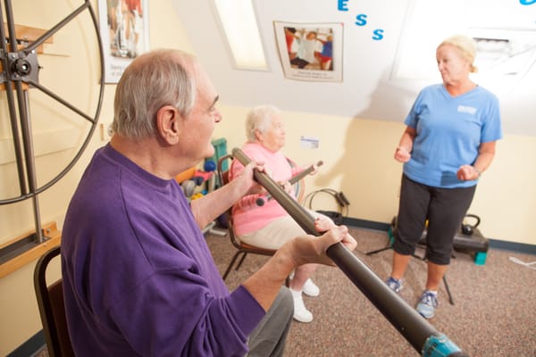 Residents engaging in an exercise activity with staff guidance