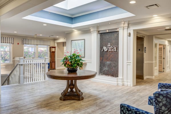 Bright lobby area with a large round table and plant