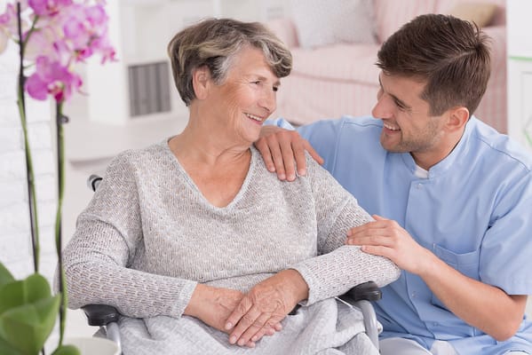 A caregiver interacting with a resident in a cozy interior