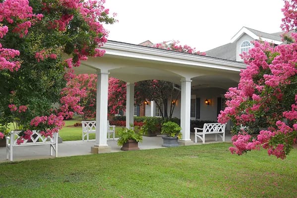 Outdoor patio area surrounded by blooming flowers