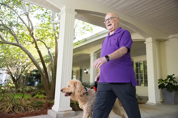 Resident walking a dog outside the facility
