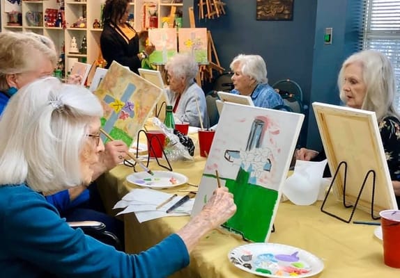 Residents painting in a bright activity room