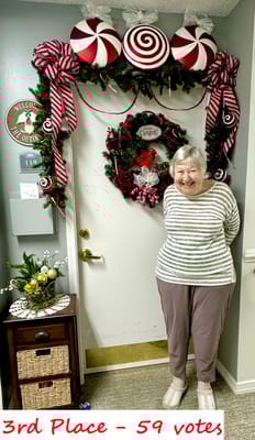 Resident smiling in front of a decorated door