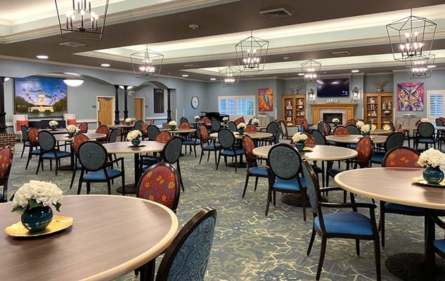 Bright dining room with round tables and flower centerpieces