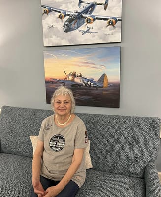 Resident seated on a couch in a decorated common area