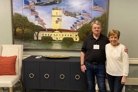 Residents posing in front of a decorated wall