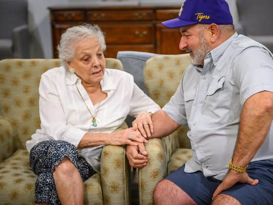 An elderly resident and a visitor sharing a moment