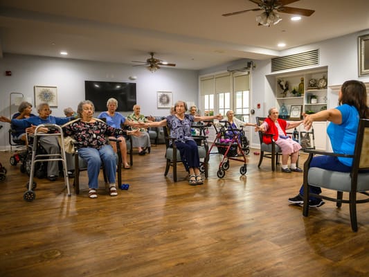 Residents participating in a group exercise class in a common area