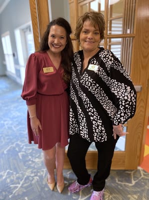 Two staff members posing together in a facility