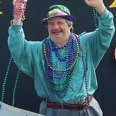 A resident celebrating with Mardi Gras beads