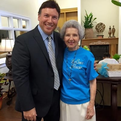 Resident and staff member smiling together in common area