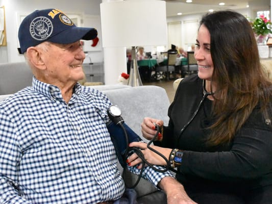 Staff member checking a resident's blood pressure