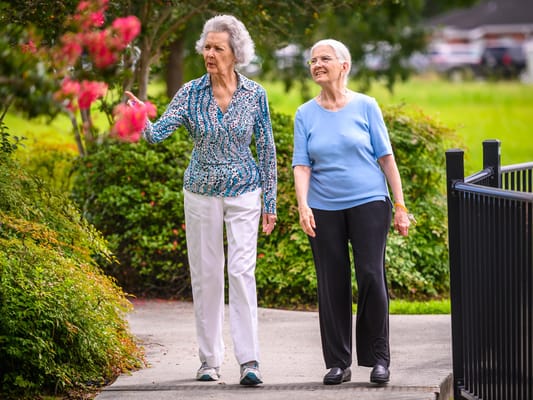 Two residents walking in a garden area