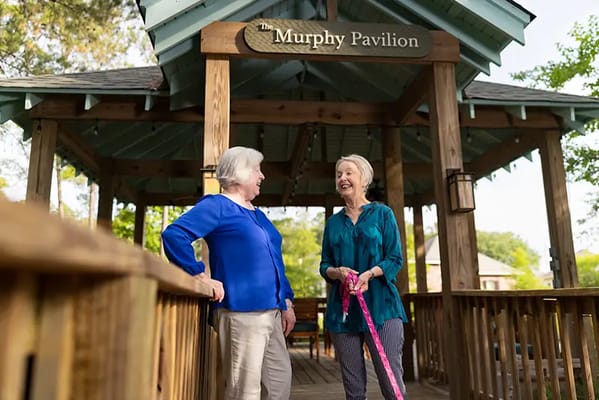 Two residents chatting on a pavilion deck