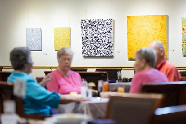 Residents socializing over breakfast in a dining area