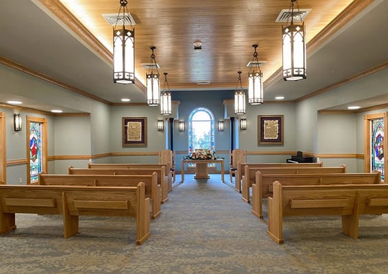 Interior view of a serene chapel with wooden pews