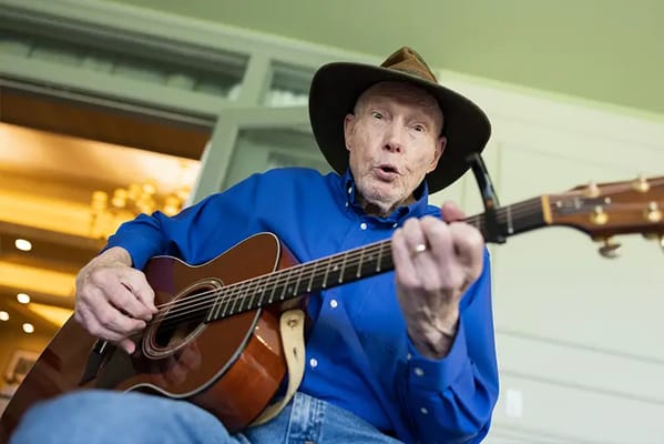 Resident playing guitar in a common area