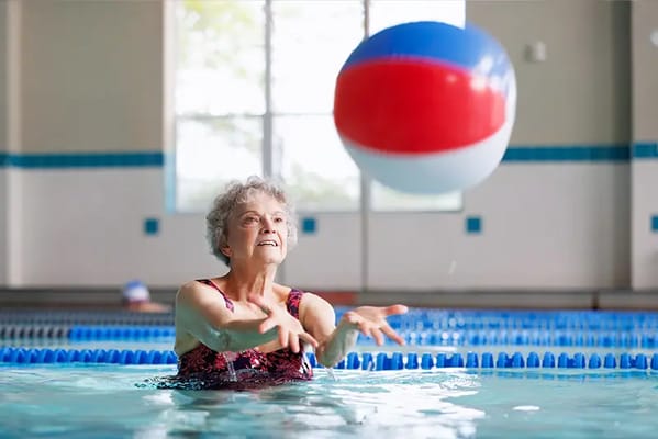 Resident playing in the pool with a beach ball