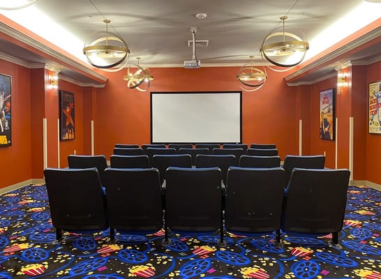 Theater room with seating and a projector screen