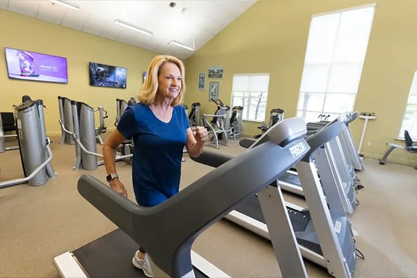 Woman exercising on a treadmill in a fitness room
