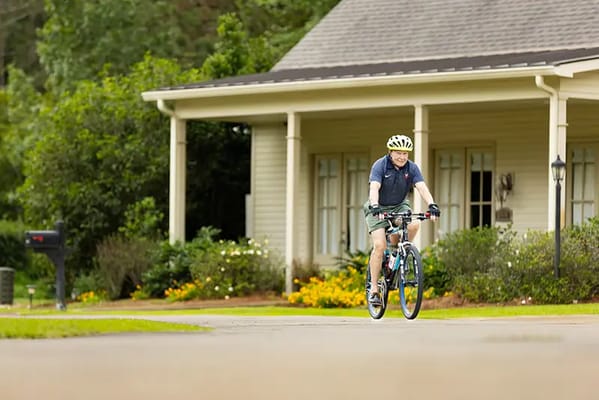 Resident riding a bicycle in front of the facility