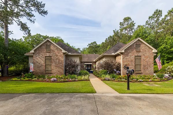 Exterior view of a brick building surrounded by gardens