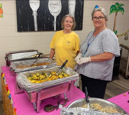 Staff serving food at a dining event in the facility