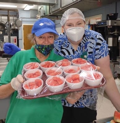 Residents and staff preparing food in the kitchen